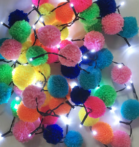 Brighten up your days by tying multicoloured pompoms to a string of fairy lights.