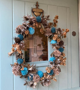 What a lovely welcome to your home. This gorgeous door decoration is enhanced with a few blue pompoms and natural foliage.