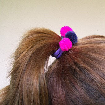 Easily tie a bunch of pompoms to a hair elastic to jazz up your hair style.