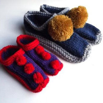 These beautiful handknitted slippers have had large matching pompoms sewn onto them.
