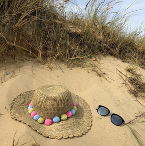 A simple makeover.  Personalise a plain sun hat by stitching/tying little pompoms to it.