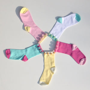Accessorise some childrens socks using your Multipom. Co-ordinating the yarn with the socks, make 16 pompoms at a time, stitching 8 to each sock.