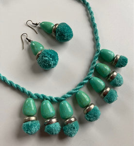 Coordinate a necklace and matching earrings to your outfit. The beads and pompoms are attached to a handmade cord, instructions for which are in our project book.
