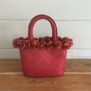 Red pompoms tied to around the top of this little red bag make it extra special.