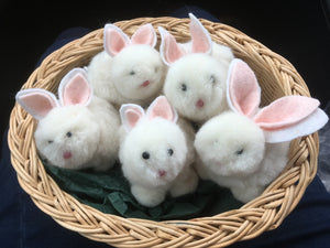 A basket of bunnies. Made by tying different sized pompoms together for the bodies, heads and tails and adding eyes, noses and ears.